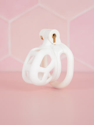 The Cobra Flat Cuff Nub in white, it is shown here fully assembled in front of a pink background.