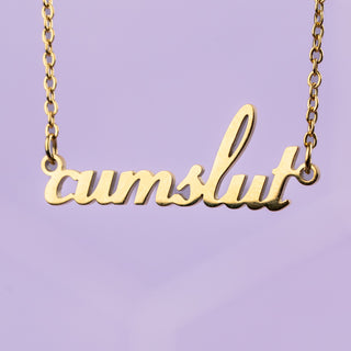A close up image of the cumslut necklace and its gold chain