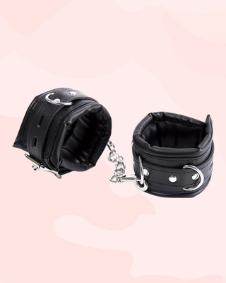 The black leather wrist cuffs shown locked together.