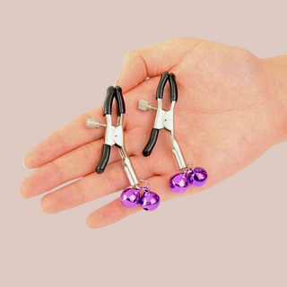 The nipple clamps shown being held in a hand to provide an idea of size.