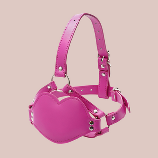 A bright pink PVC dildo head gag, you can see from the image how the gag fits around the head, it has adjustable straps and a dildo is attached to the inside of the mouth gag.