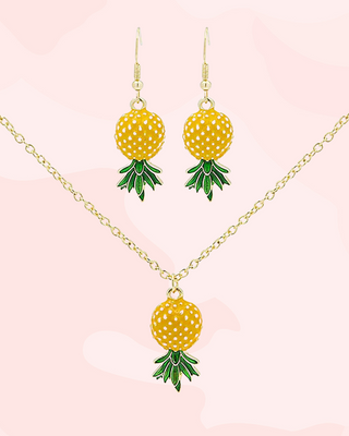 Pineapple-themed necklace and earrings on a pink background
