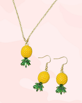 Pineapple-themed jewelry set including necklace and earrings on a pink background