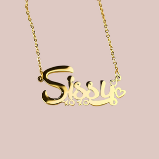 A close up of the gold Sissy necklace with xoxo beneath and hearts at the end.