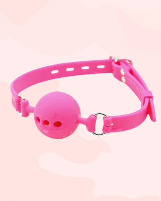 The pink Velvet Bite ball gag shown with droplets of water on it, it is waterproof