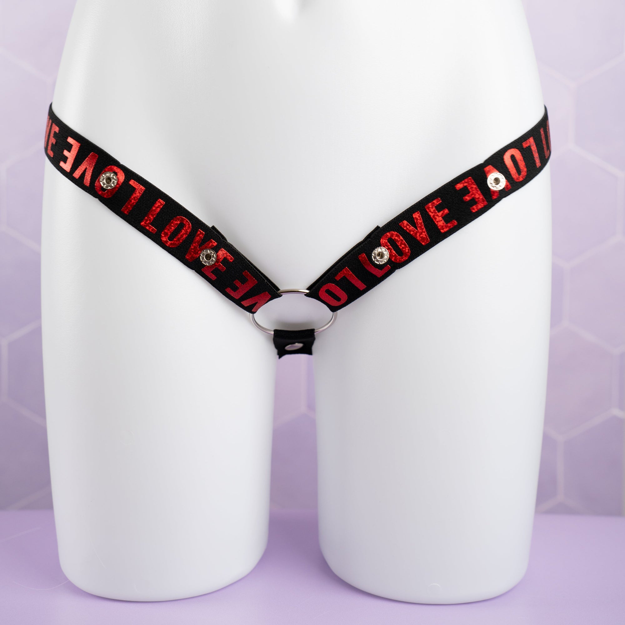 A front on view of the 3 Way Restraining Chastity Belt shown here in our red. You can see the adjustable poppers and the included ring.