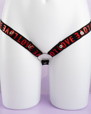 A front on view of the 3 Way Restraining Chastity Belt shown here in our red. You can see the adjustable poppers and the included ring.