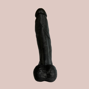 A rear view of the super sized dildo, you can see the ball sack hanging down and the veining to the body and the shaped head.