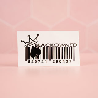 A close up of the Black Owned Temporary Tattoo in front of a pink background