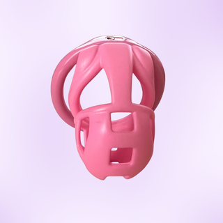 A straight on view of the pink chastity cage, it is shown on a purple background