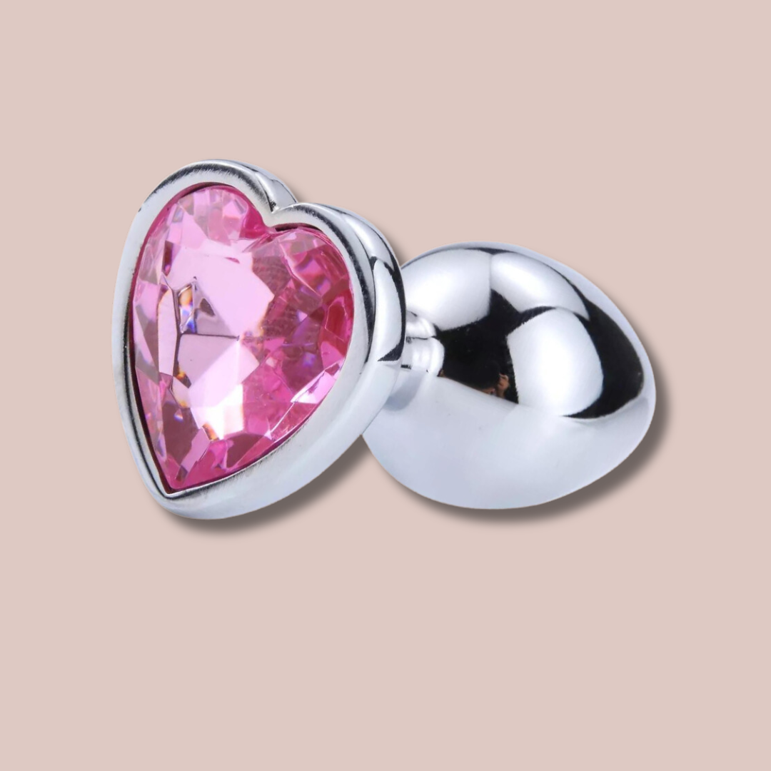A close up view of the heart shaped pink. jewelled end to the large butt plug from House Of Chastity.