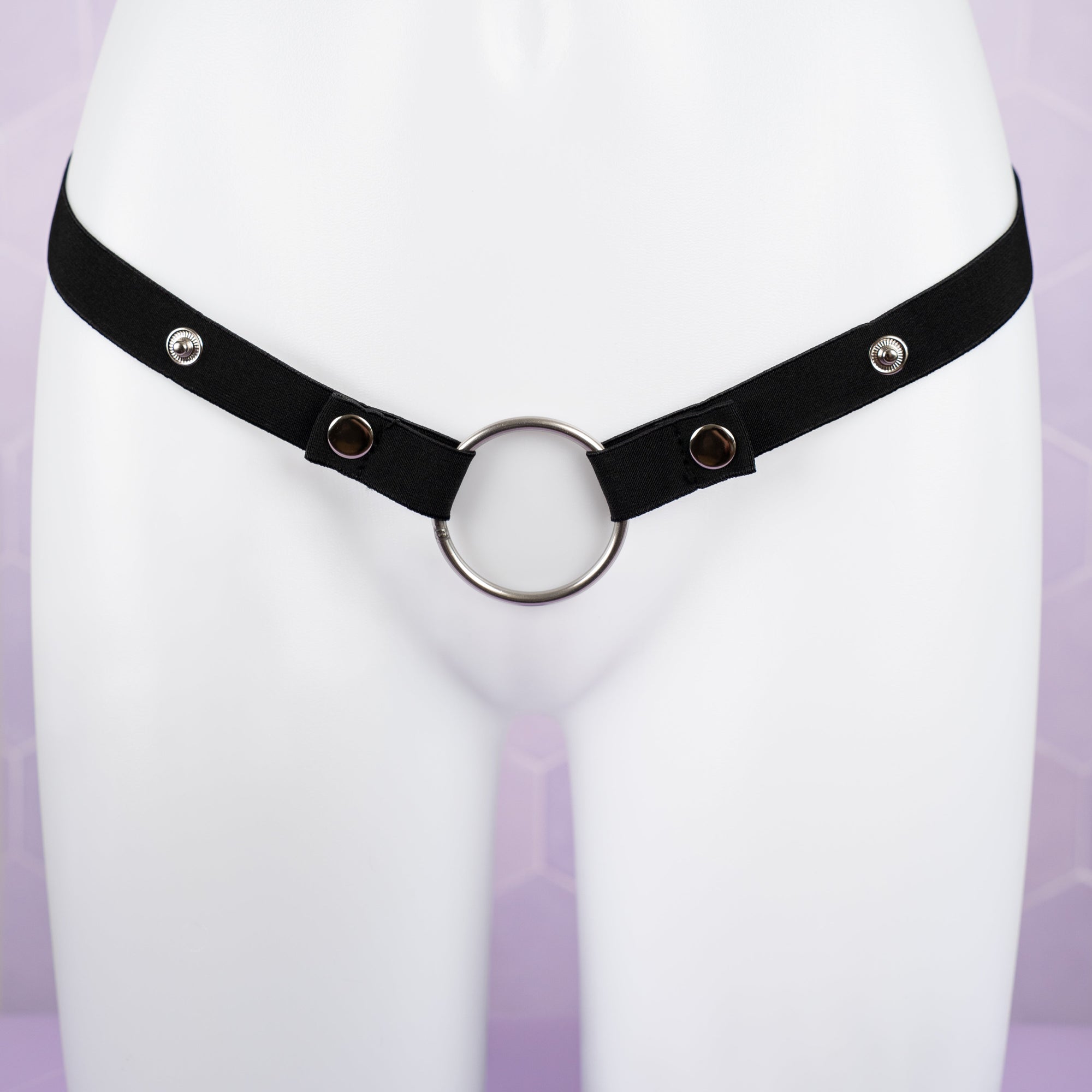 Black elasticated chastity belt shown with metal 45mm ring and the poppers that allow the waist size to be adjusted.