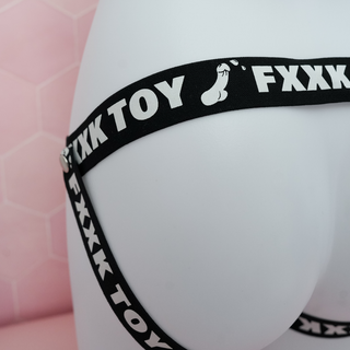 A close up side view of the chastity belt, the FXXK TOY logo and spurting penis can be seen.