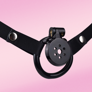 The Flat Gatling chastity cage in black is shown on a matching black chastity cage belt. Belt available separately.