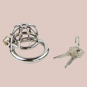 A stainless steel chastity cage in extra small size. The head is designed in an spaced, umbrella bar design and has a centre hole to allow a urethral tube to be attached if desired. The cage has one ring, that the cage attaches to and when joined, the integral lock can be fixed into place. It comes with one lock and 2 keys.