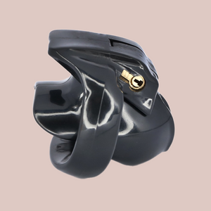 Shown is the black nub cock cage that we offer in our version of the Holy Trainer range. It is shown from the side angle so that you have a full view of the assembled chastity cage, the cock cage is shown attached to a base ring and the integral lock is in place, showing how it fits to the body. This product is the pink version, these cages also come in pink and clear.