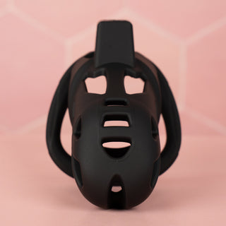 A front on view of The Jeusn chastity cage on a pink background.
