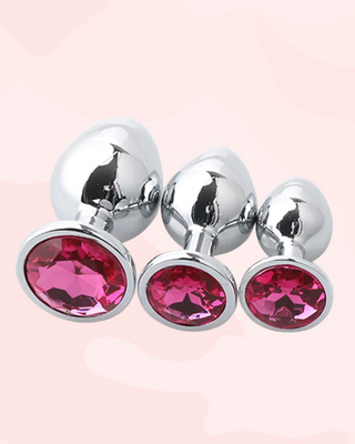 Three metallic butt plugs with rose pink gemstones