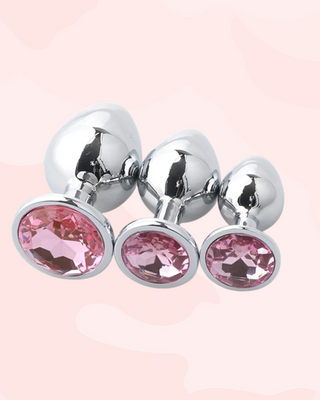 Three metallic anal plugs in small, medium and large, with light pink gem stones