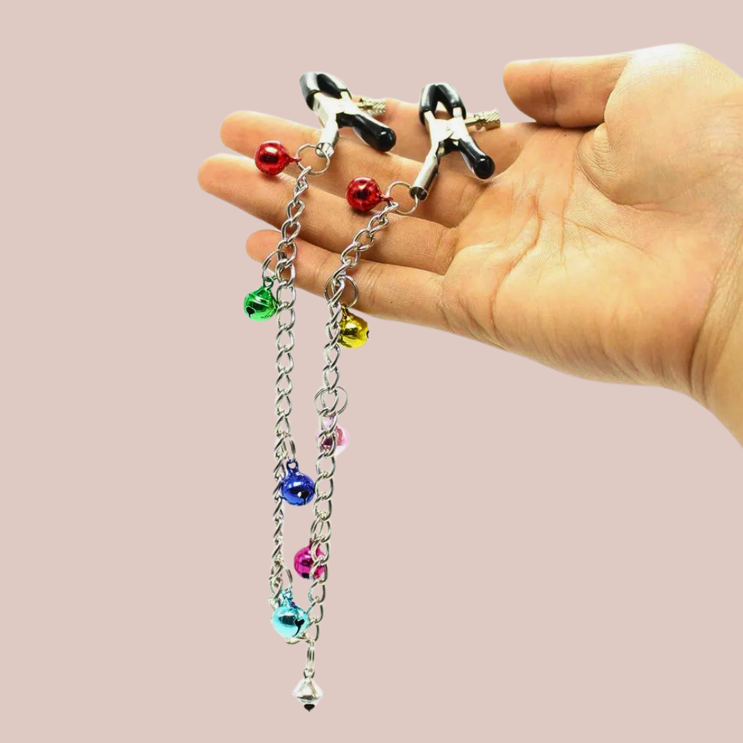 The long length nipple clamps shown being held, you can see the chain with the decorative bells hanging.