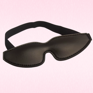 The eye mask sitting on a pink background