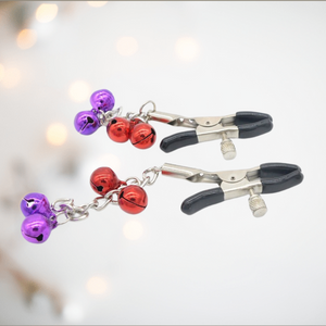 Alternate colour Nipple Clamps with decorative bells from House Of Chastity are shown here, you can see the stainless steel clamps with tightening screws. From them flows a pretty chain with decorative bells.