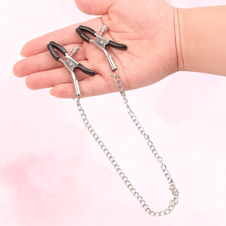 The black tipped nipple clamps shown on a hand for size comparison