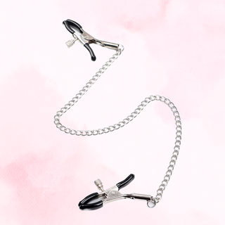 The Nipple Clamps lying flat on a pink background