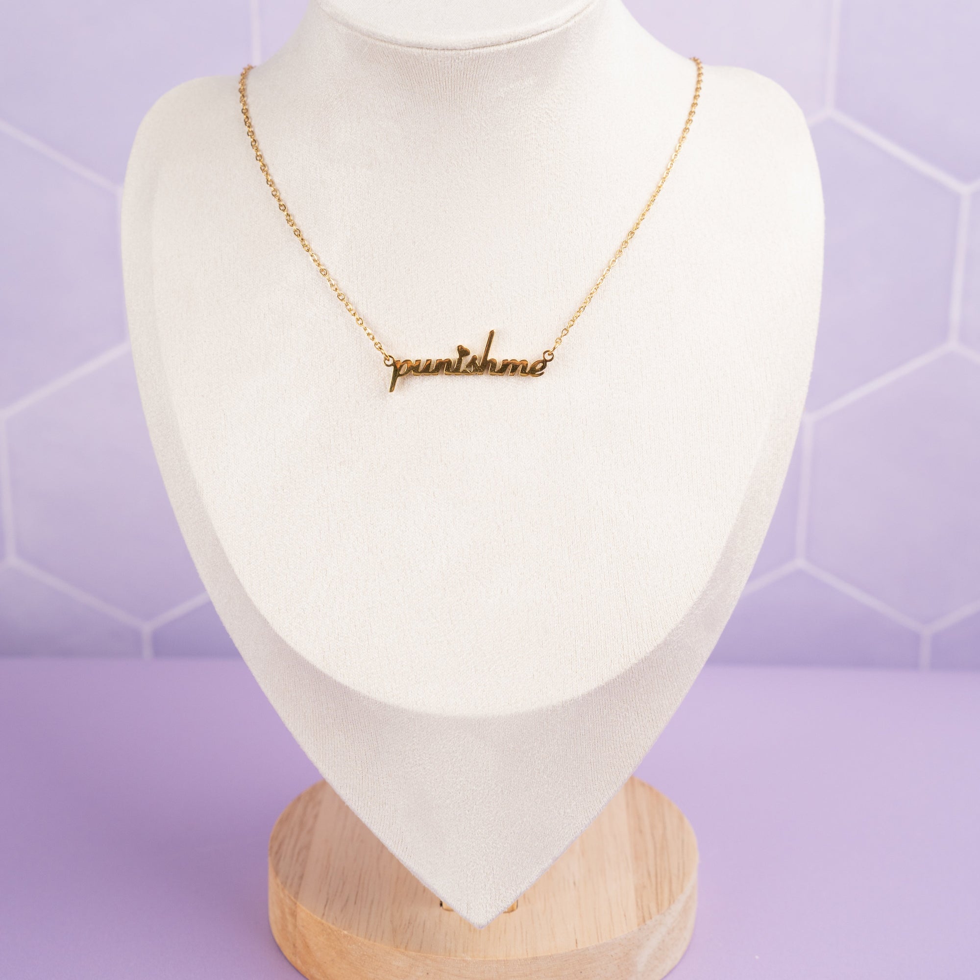 Gold 'Punish Me' necklace displayed on a mannequin, showcasing how the pendant hangs and the chain's elegant drape for a realistic styling reference