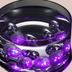 Showing a bowl full of remote control light up anal plugs submerged in water from House Of Chastity