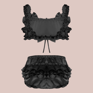 A rear view of the black  Frilly Satin Bra Top & Panties from House Of Chastity. You can see the decorative bows and ruffled skirt.