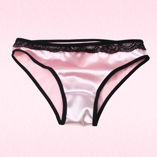 Pink satin briefs with black lace trim and black edge piping, displayed flat against a light pink background.