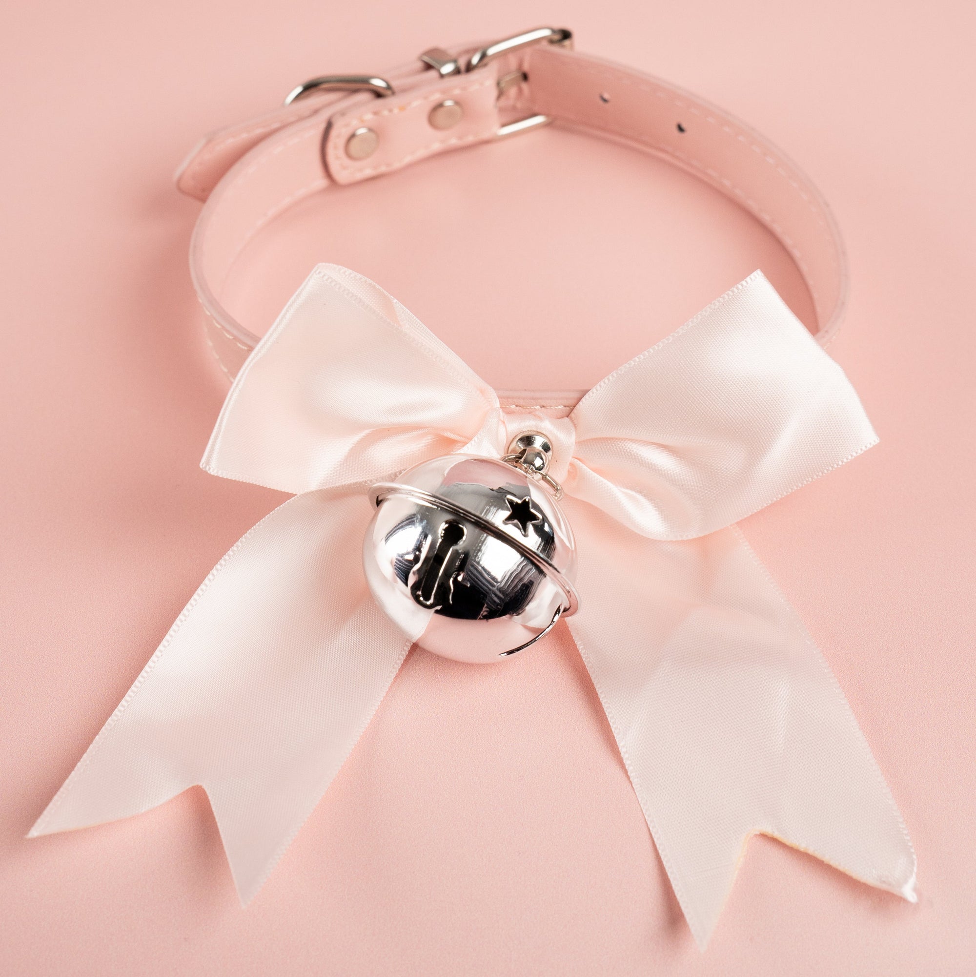 The pink soft ribbon collar bow from House Of Chastity, shown is the pink collar, matching soft satin ribbon and silver bell perfect attire for any sissy.