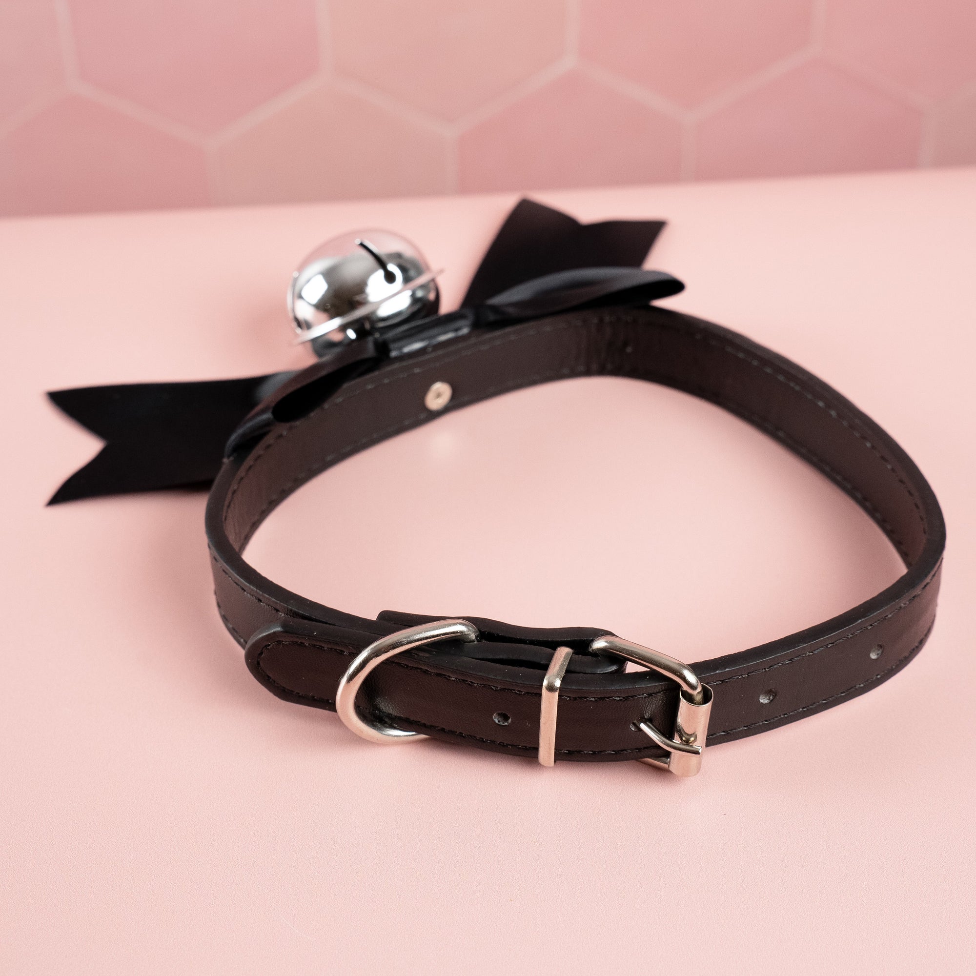 Showing the adjustable collar and buckle closure on the black satin soft bow collar.
