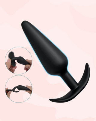 Black silicone butt plug with two separate images showing how malleable the product is, it's shown on a light pink background