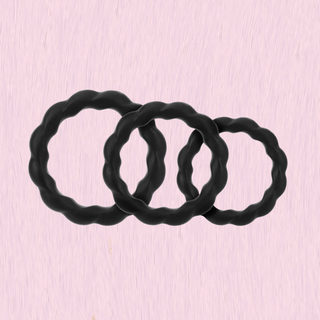 set of 3 silicone cock rings in black on a pink background