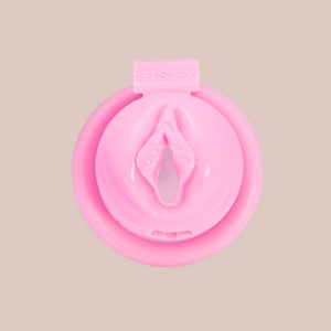 A frontal look at The Sissy Pussy III Chastity Cage from House Of Chastity. It's a small baby pink cage with a circular front with an open labia and the word Sissy displayed at the top.