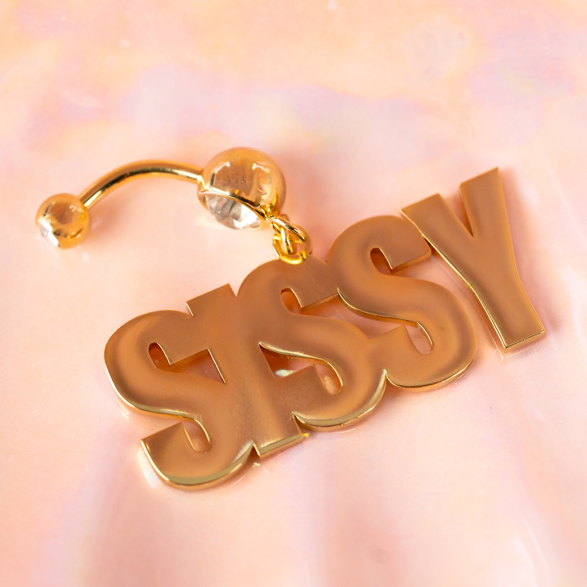 Gold Sissy navel piercing featuring a delicate design with elegant detailing. The jewelry has a shiny gold finish, crafted for a stylish and bold look