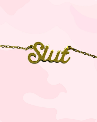 A close up of the Slut lettering on the pendant necklace