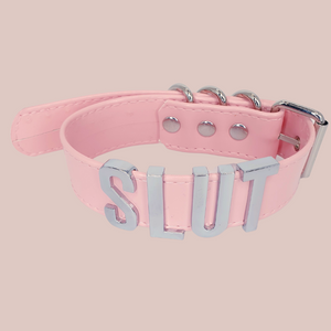 The pink Slut collar with silver lettering and fastenings.