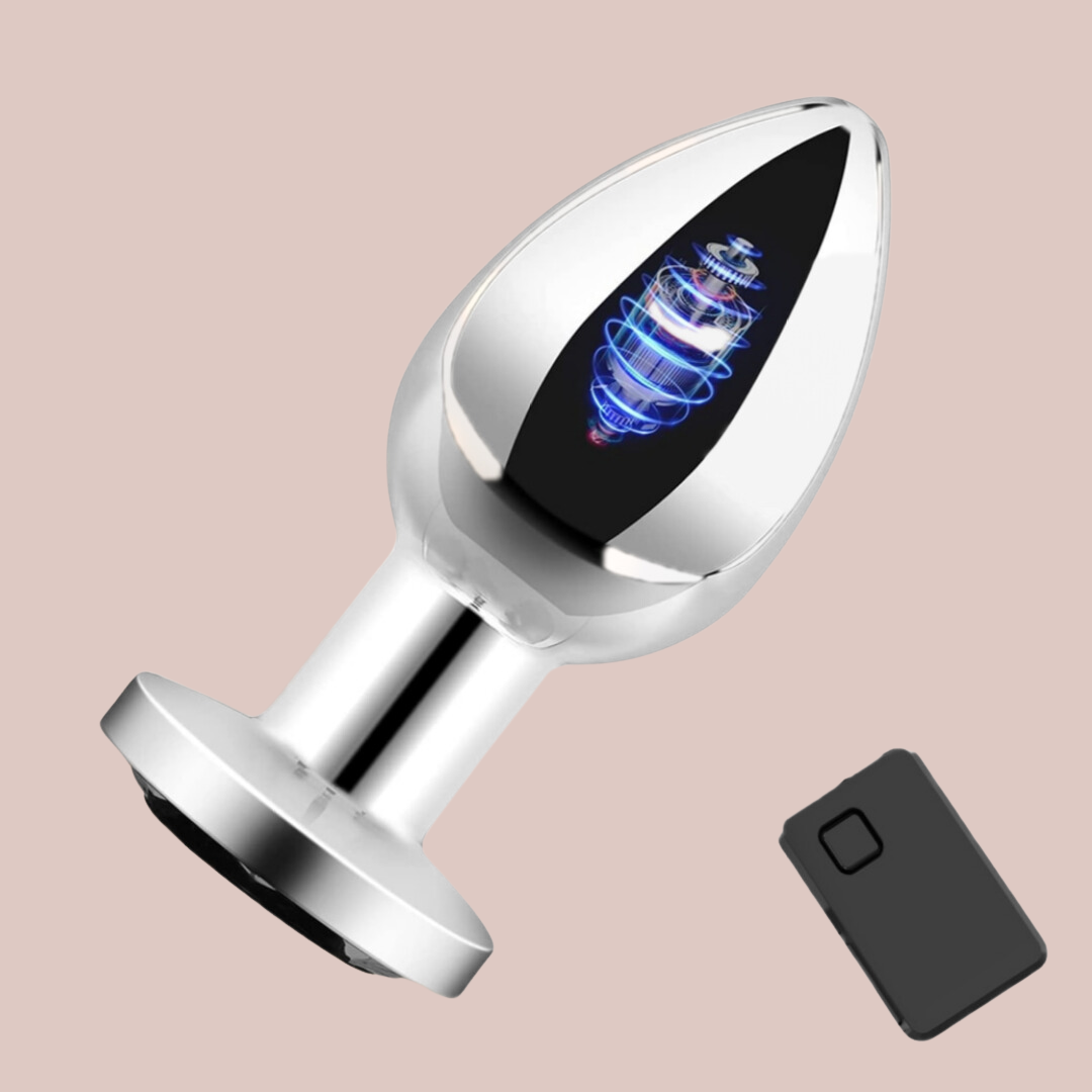 A side profile of the wireless vibrating stainless steel anal plug, it shows the battery inside to suggest how the wireless control is used. Also shown is the small hand control for the device.