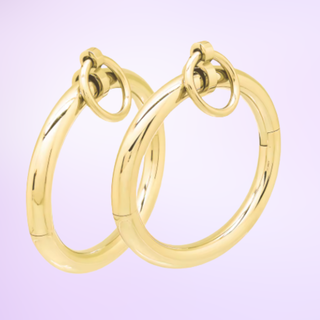 The gold Sub Rosa Locking Bracelet cuffs on a purple background.