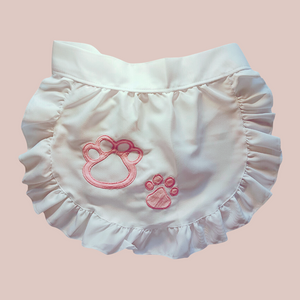 A close up of the apron from The Bella Maids Dress from House Of Chastity. The apron is fully removable, and has a paw print motif.