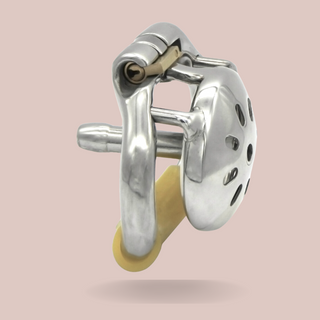 A side view of The Enthrallment, Showing the cage with cut out hole design, attached stainless steel urethral tube, base ring and integral lock.