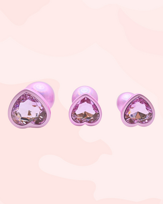 The jewelled ends of the three different sizes of butt plug are shown, the jewel is in a pale pink to match the pale pink pearl colouring