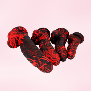 Four of the red and black mottled pattern Wyvern Whisper dildo's, they are shown lying next to each other.