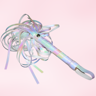 The flogger is shown with the tails jumbled, it is lying on a pink background.