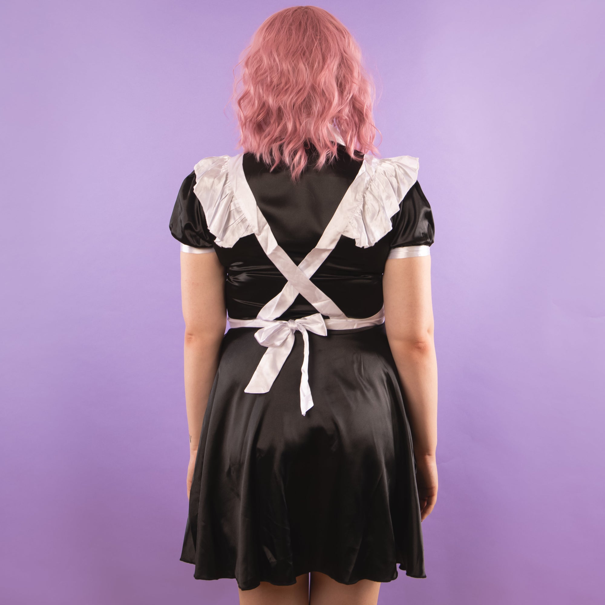 A rear view of The Belinda Maid Dress, the apron falls over the shoulders and ties at the waist.