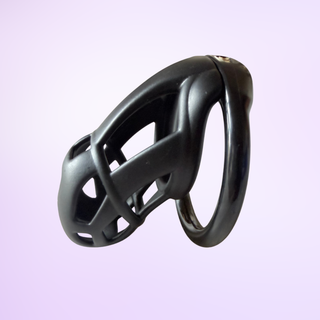 A side view of the black Cobra Naja small chastity cage on a pink background