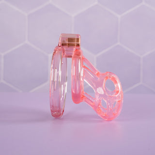 A side view of the pink chastity cage, the lock is in place.